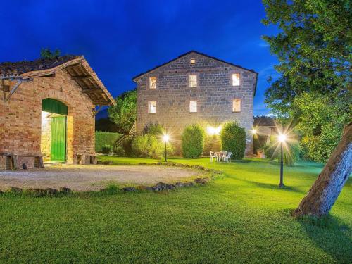 a large stone building with lights in the yard at Magnificent Holiday Home in Amandola with 2 Private Pools in Amandola