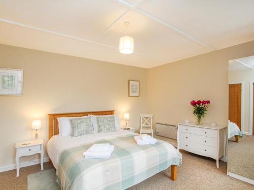 a bedroom with a large bed and a mirror at Bryn Eira Tack Room in Llanfairpwllgwyngyll