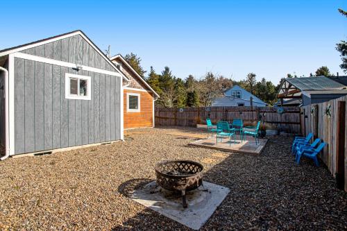 a backyard with a fire pit and a fence at Siletz Bay Getaway in Lincoln City