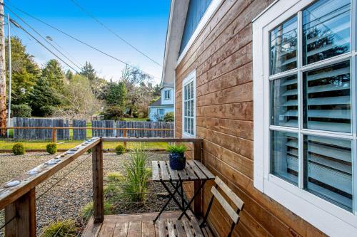 a wooden balcony with a table and a window at Siletz Bay Getaway in Lincoln City