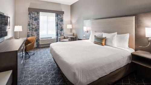 una camera d'albergo con un grande letto e una scrivania di Best Western Plus Lawrenceburg a Lawrenceburg