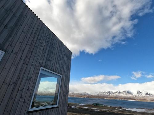 a window of a building with mountains in the background at Sunnuhlid houses in Akureyri