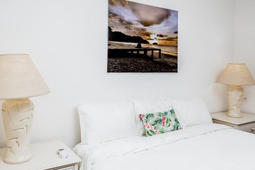 a living room with a white couch and a picture on the wall at The Palms At Coco Beach in Coco