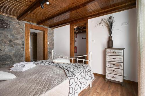 a bedroom with a bed and a stone wall at Ga281 in Funchal