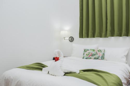 a white bed with a stuffed animal on it at The Palms At Coco Beach in Coco