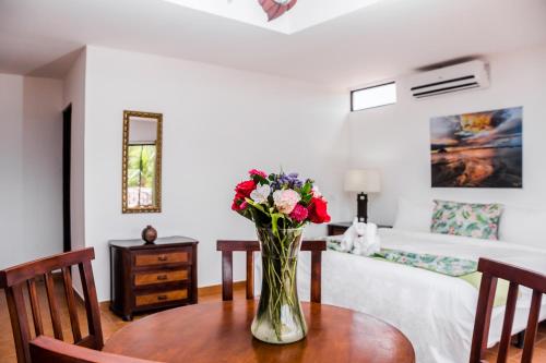 a vase of flowers on a table in a bedroom at The Palms At Coco Beach in Coco