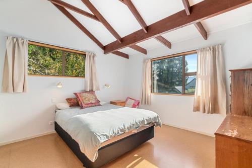a bedroom with a bed and two windows at Goodall Crib - Wanaka Holiday Home in Wanaka