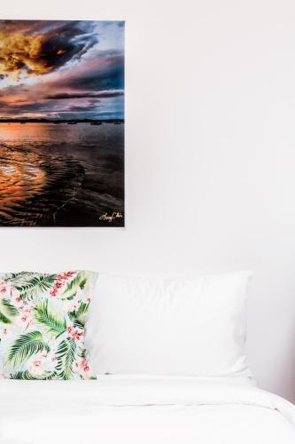 a bedroom with a bed with a picture of the ocean at The Palms At Coco Beach in Coco