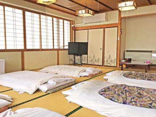 a room with four blankets on the floor with windows at Ohmachiso in Akita
