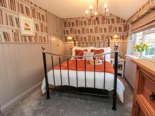 a bedroom with a bed and a chandelier at Esk View Cottage in Grosmont