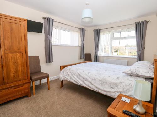 a bedroom with a bed and a chair at Elliott's Retreat in Sheringham