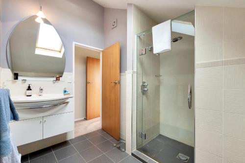 uma casa de banho com uma cabina de duche em vidro e um lavatório. em Dangela Boutique Lodge em Auckland