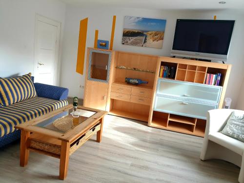 ein Wohnzimmer mit einem Sofa und einem TV in der Unterkunft Nordsee in Wilhelmshaven