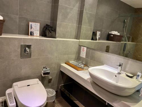 a bathroom with a white toilet and a sink at 3 Door Hotel in Tainan