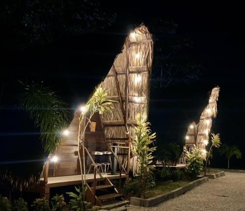 a wooden house with lights on it at night at Termales del Arenal in Fortuna
