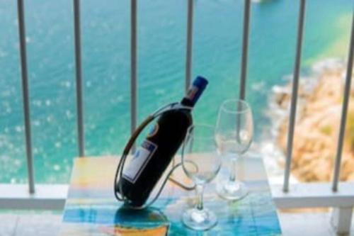 una botella de vino sentada en una mesa con dos copas en Suite frente al mar en el corazón de Acapulco en Acapulco
