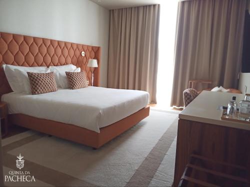 a hotel room with a bed and a large window at Pacheca The Wine House Hotel e Spa - Quinta da Pacheca in Lamego