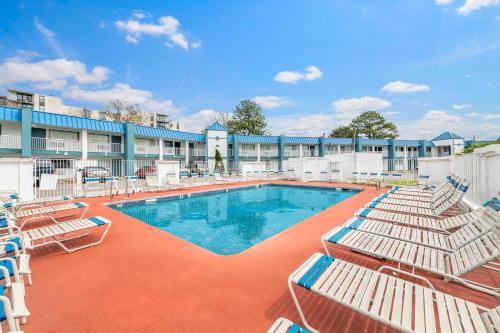 a swimming pool with lounge chairs and a hotel at Super 8 by Wyndham Portsmouth - Norfolk in Portsmouth