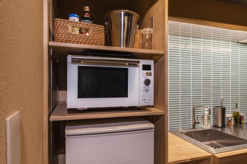 a microwave sitting on a shelf in a kitchen at Shiki Homes KUMEI in Kyoto