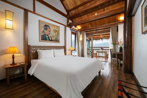 a bedroom with a large white bed in a room at Mai Chau Hideaway Lake Resort in Mai Chau