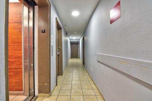 a hallway with a long corridor with doors and a tile floor at Econo Lodge Inn & Suites Virginia Beach - Norfolk in Virginia Beach