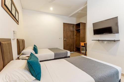 モンテリアにあるHotel Ayenda Boutique Rio Montのベッド2台、薄型テレビが備わるホテルルームです。