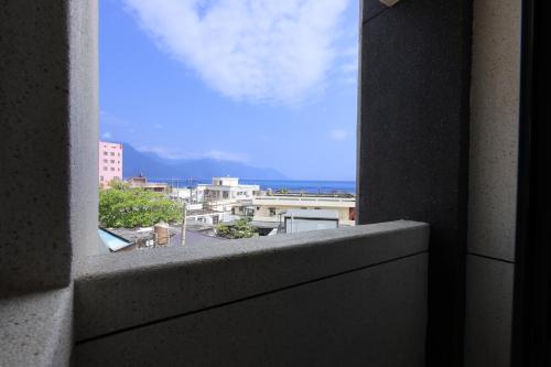 a view of a city from a window in a building at 七星潭118海景民宿 in Dahan