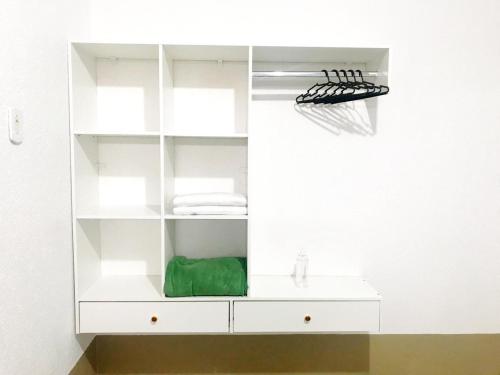 une armoire de salle de bain blanche avec une serviette verte dans l'établissement Aeroporto House 2, à Macapá
