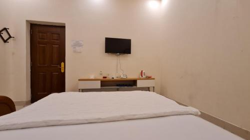 a bedroom with a bed and a tv on a wall at Sky Hotel in Bien Hoa
