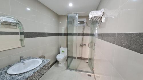 a bathroom with a shower and a sink and a toilet at Sky Hotel in Bien Hoa