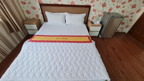 a bedroom with a large white bed in a room at Sky Hotel in Bien Hoa