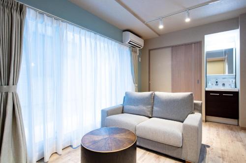 a living room with a chair and a table at VILLA KOSHIDO KOTONI annex in Sapporo
