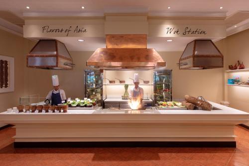 a bakery counter with two chefs in a kitchen at Sofitel Angkor Phokeethra Golf & Spa Resort in Siem Reap