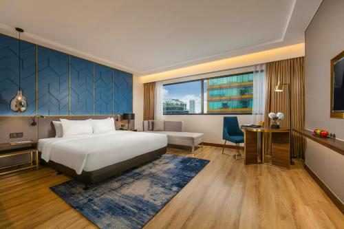 a hotel room with a bed and a desk at Mövenpick Living West Hanoi in Hanoi