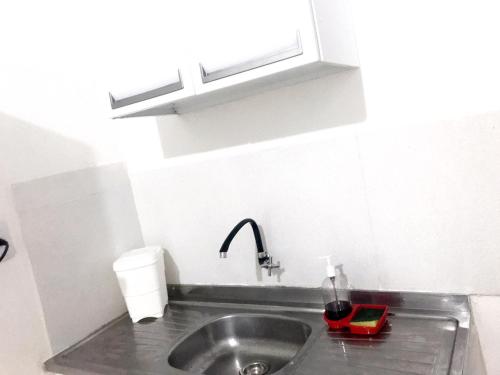 um lavatório de cozinha com uma torneira e uma tigela vermelha em Aeroporto House 2 em Macapá