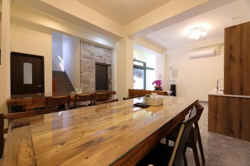 a large wooden table in a room with chairs at 七星潭118海景民宿 in Dahan
