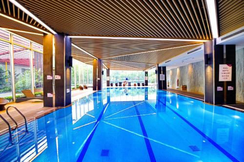 a swimming pool with blue water in a building at Crowne Plaza Shanghai Xiayang Lake, an IHG Hotel in Qingpu