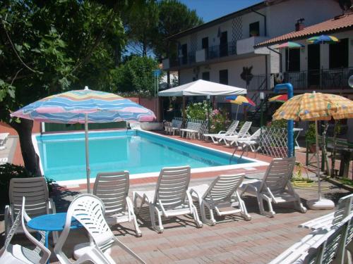 a group of chairs and umbrellas next to a pool at Residence Al Lago in Castiglione del Lago