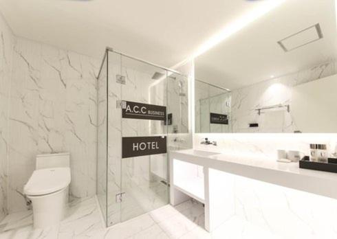 a bathroom with a toilet and a hotel sign on the wall at Sinan Equelim Hotel in Gwangju