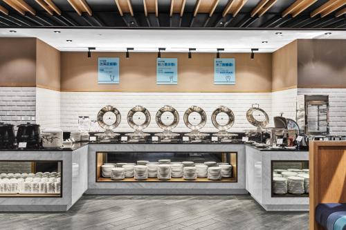 a kitchen with sinks and mirrors on the wall at Holiday Inn Express Kaohsiung Love River, an IHG Hotel in Kaohsiung