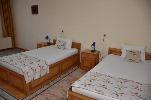 a bedroom with two beds and two night stands at Хотел Сима in Beklemeto