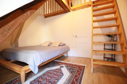 een slaapkamer met een bed en een houten trap bij Charmante maison de Pêcheur à Trouville in Trouville-sur-Mer