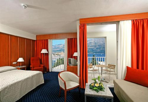 a hotel room with a bed and a balcony at Marko Polo Hotel by Aminess in Korčula