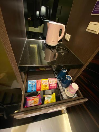 a drawer in a counter with food and a coffee cup at OUGE Motel - Fengshan in Kaohsiung