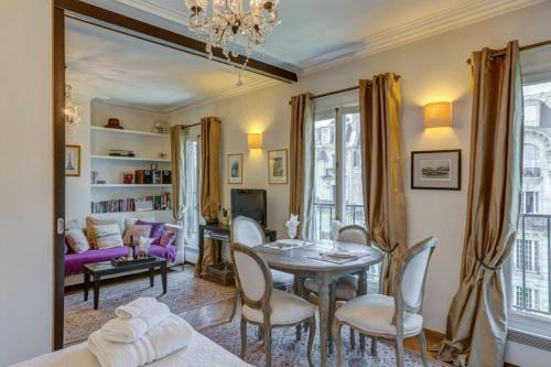 - un salon avec une table et un canapé violet dans l'établissement 27 avenue de la bourdonnais 75007 CHABLIS, à Paris