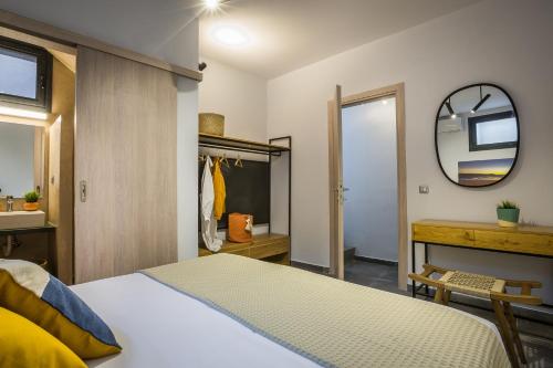 a bedroom with a bed and a mirror and a sink at Ionian Village in Lixouri