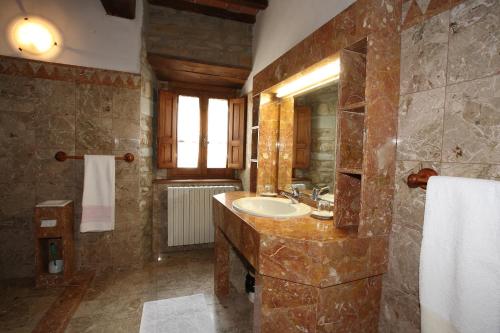 Un baño grande con lavabo y espejo. en Agriturismo Poggiolo, en Castiglion Fiorentino