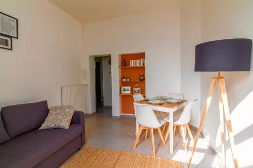 a living room with a couch and a table and chairs at Le Chanzy-Terrasse privative in Saumur