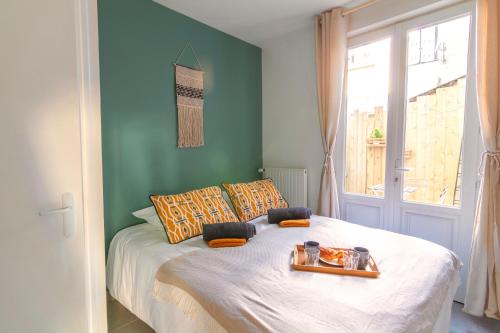 a bedroom with a bed with a tray of food on it at Le Chanzy-Terrasse privative in Saumur