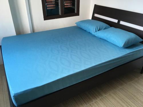 a bed with blue sheets and a blue pillow at Homey Hostel, Ipoh Town in Ipoh